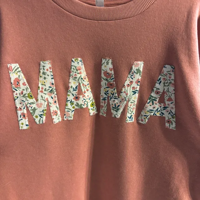 Dusty-rose crewneck sweatshirt with MAMA in large floral-fabric appliqué letters